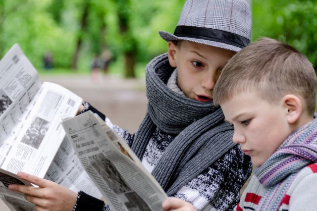 Enfants lisant Le Bien Public