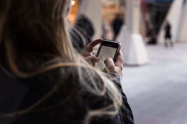 femme utilisant son smartphone avec un forfait Auchan Telecom