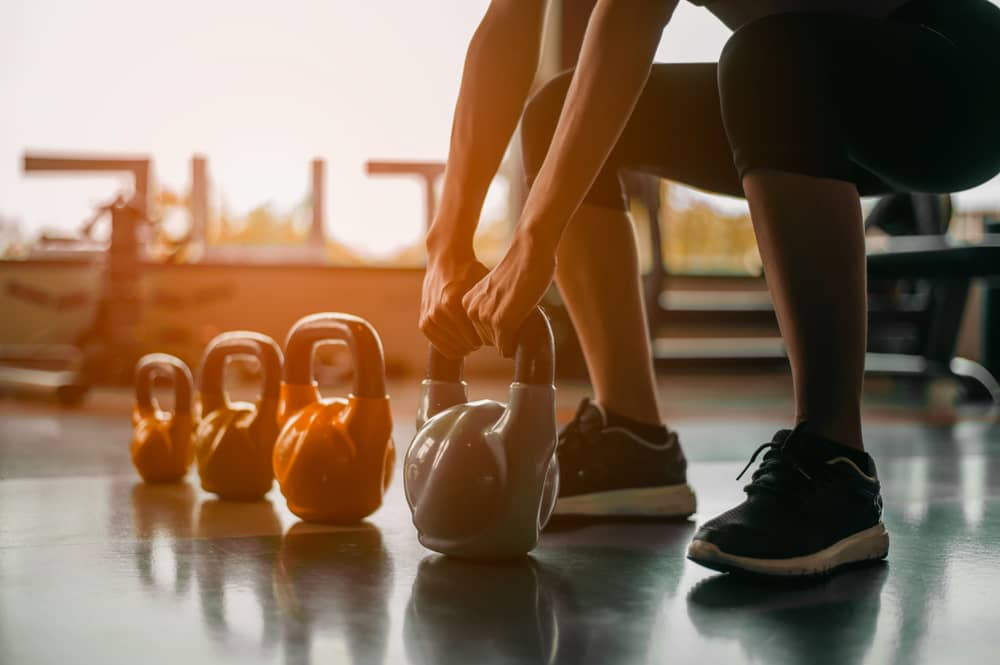 femme tenant des haltères dans une salle de sport Basic-Fit