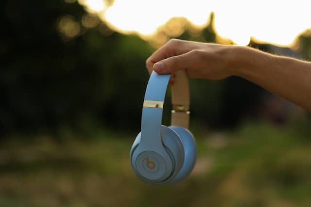 main d'une personne tenant un casque sans fil blanc de Beats by Dre
