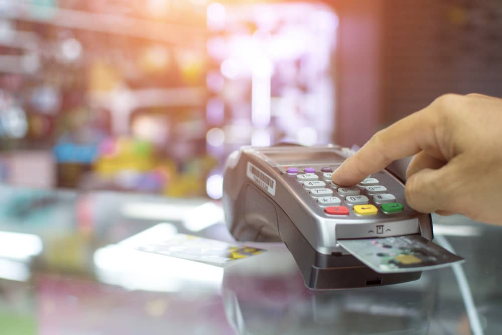 femme payant des achats en magasin avec sa carte Galeries Lafayette