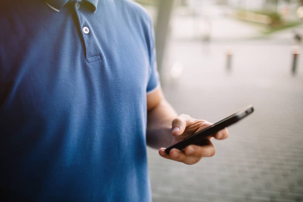 main d'un homme en train d'envoyer un SMS avec son forfait Ciel Telecom