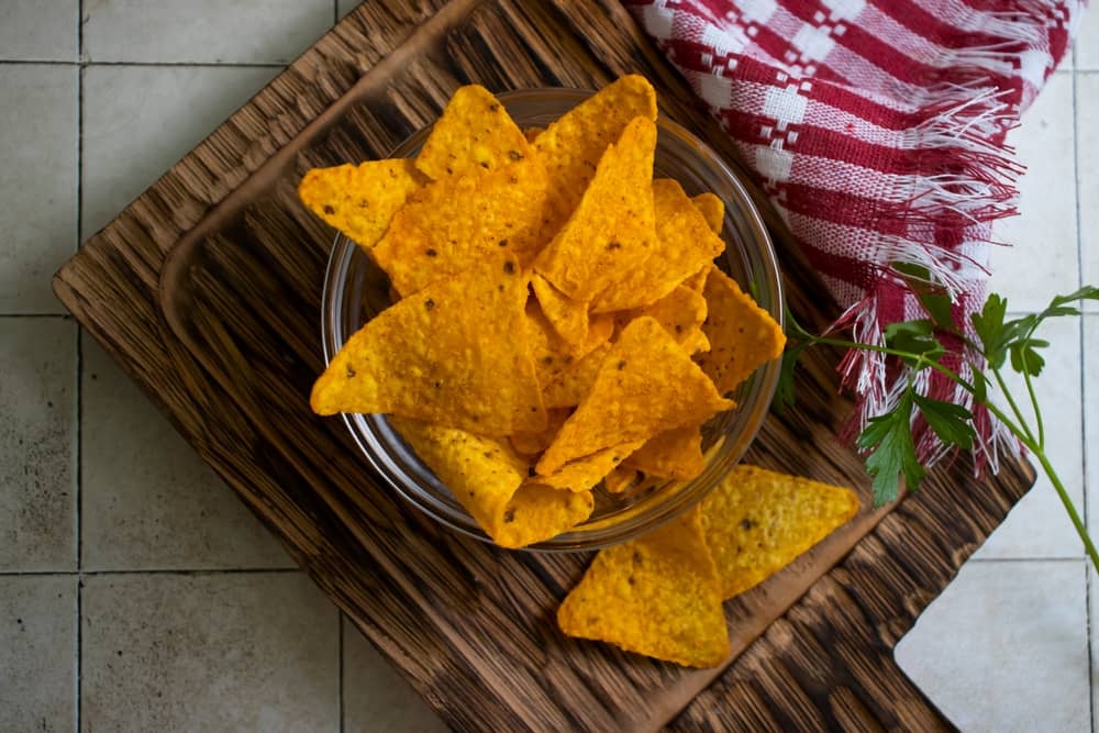 chips Doritos dans un bol posé sur une planche à découper