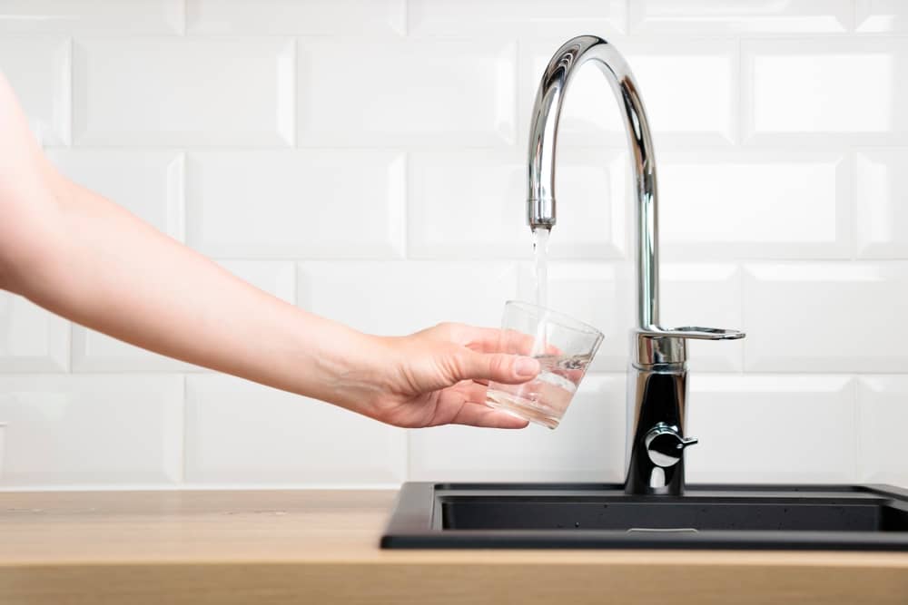 personne se servant un verre d'eau, fournie par Eaux de Normandie