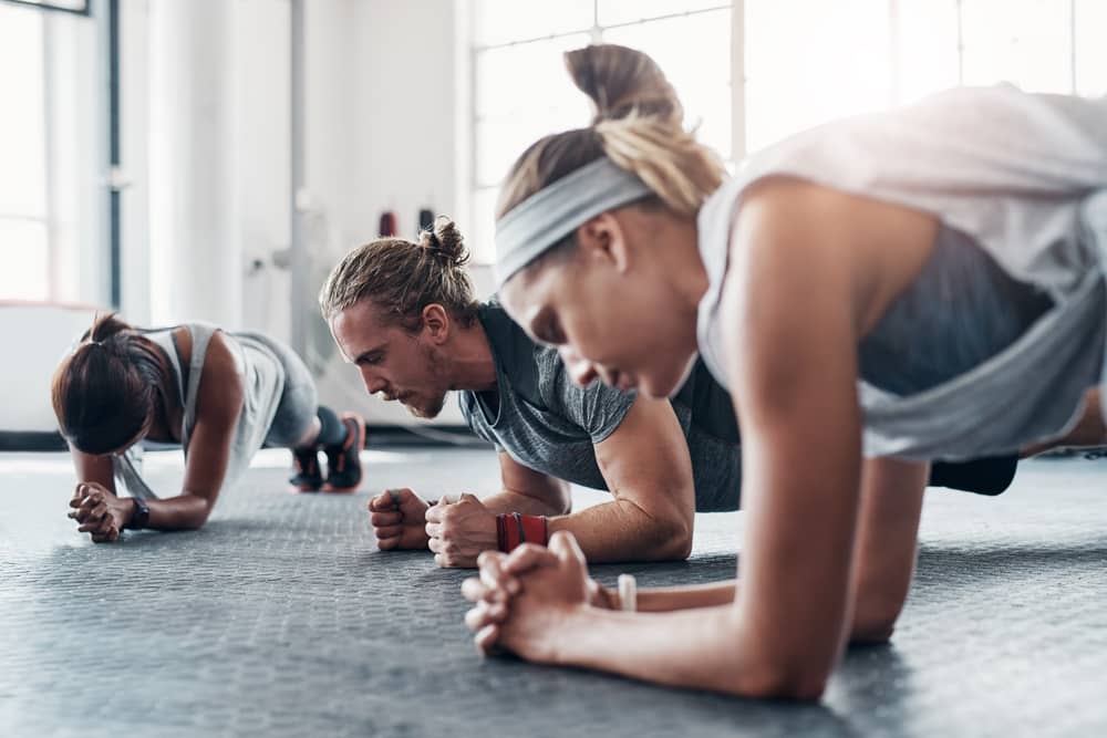 groupe de personnes faisant la planche dans une salle de sport Fitness Park