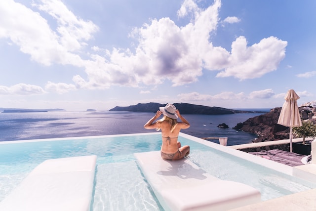femme de dos au bord d'une piscine avec vue sur la mer, lors d'un voyage organisé par Fram