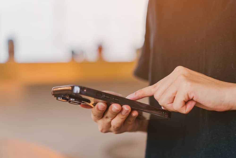 main d'une personne faisant réclamation à L'Appart Fitness depuis son smartphone