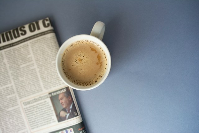 tasse de café posée à côté d'un journal L'Histoire