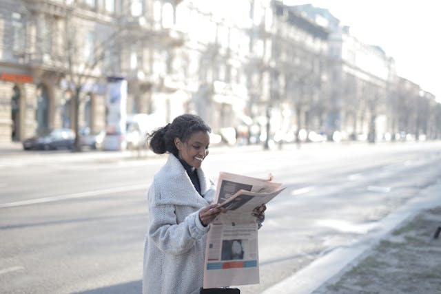 femme lisant le journal Libération dans la rue