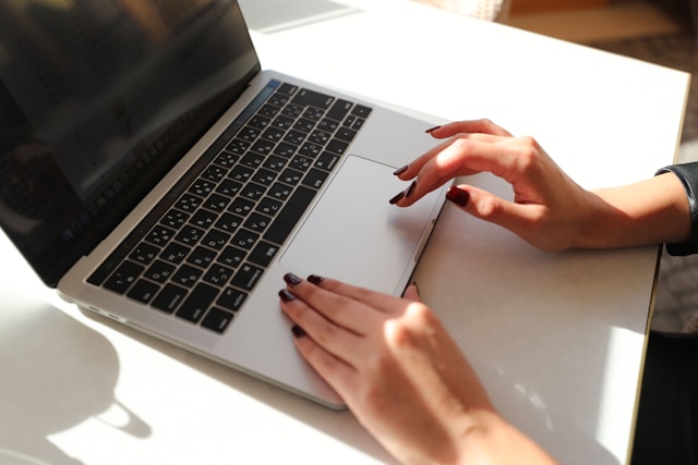 mains d'une femme consultant le site Mediapart sur son pc portable