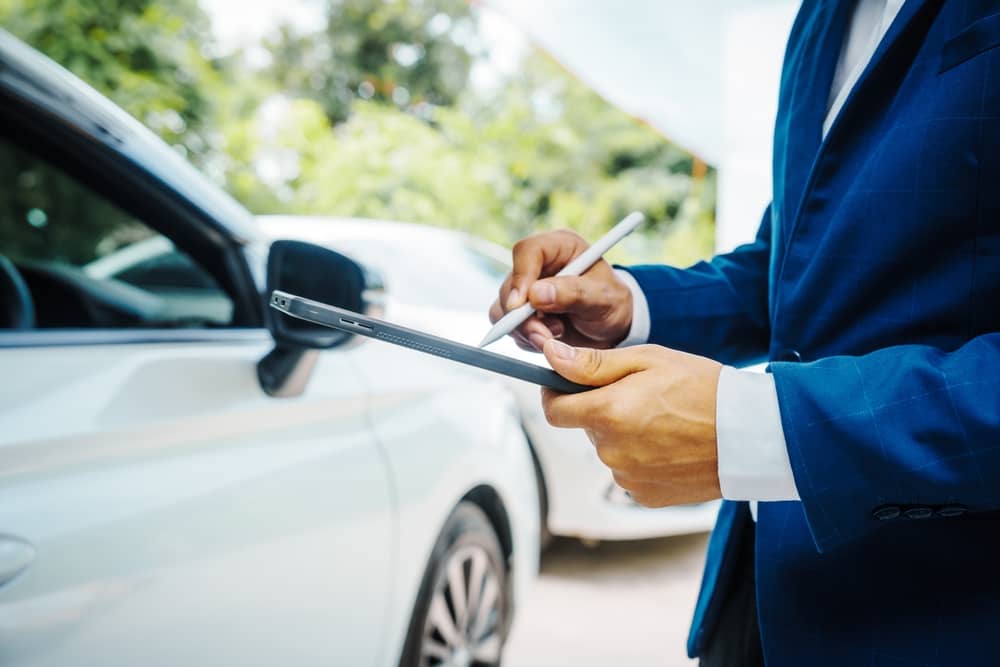 homme faisant l'état des lieux d'une voiture louée avec Modulauto