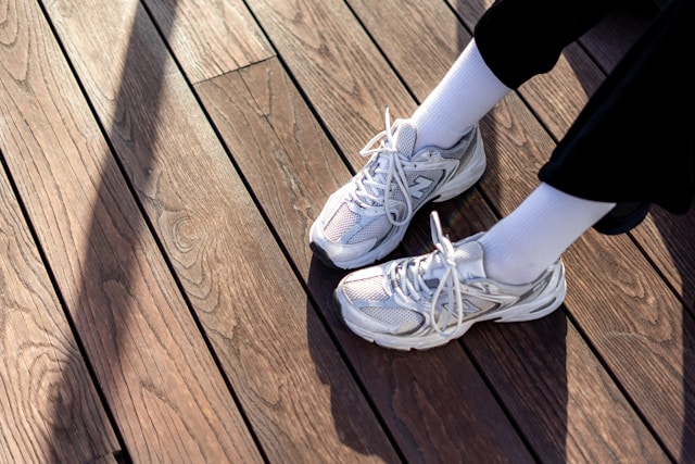 vue du dessus d'une personne portant des sneakers New Balance blanches