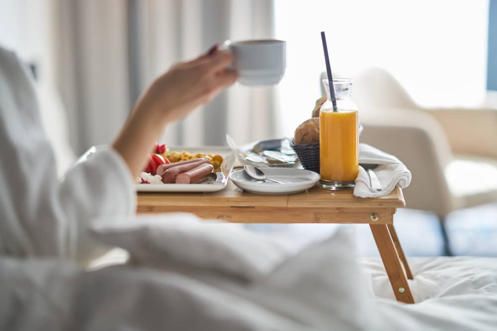 femme prenant son petit-déjeuner dans sa chambre Novotel