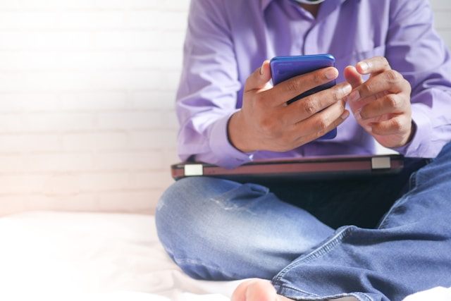 homme envoyant un SMS depuis son smartphone grâce à son forfait NRJ Mobile