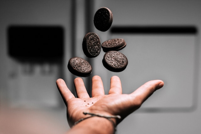 main d'une personne lançant des biscuits Oreo