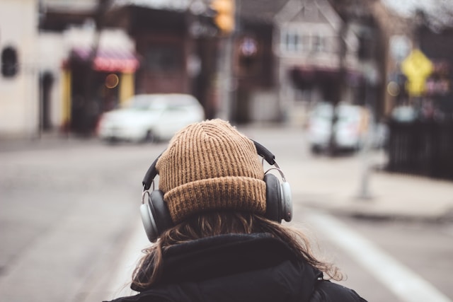personne de dos portant un casque pour écouter de la musique sur Qobuz