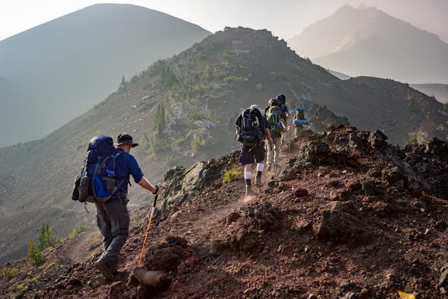 groupe d'amis faisant une randonnée en montagne avec de l'équipement Quechua