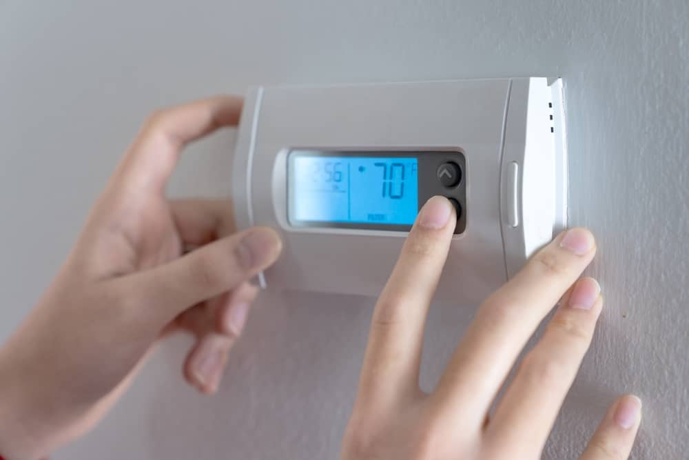 mains d'une personne réglant son thermostat SEFE Energy