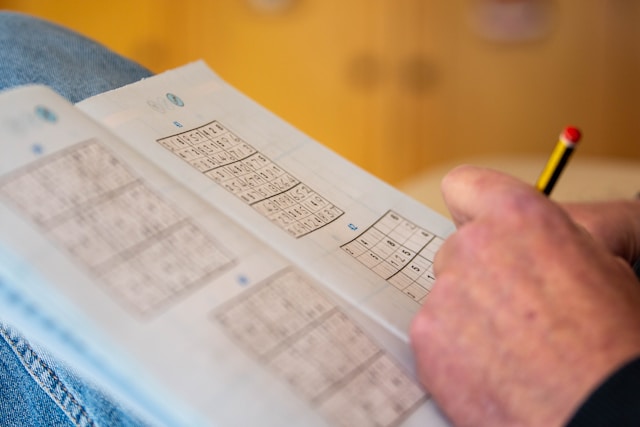 personne remplissant un sudoku dans un Télé 7 Jeux