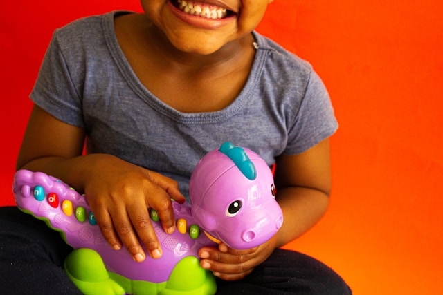enfant tenant un jouet électronique VTech en forme de dinosaure